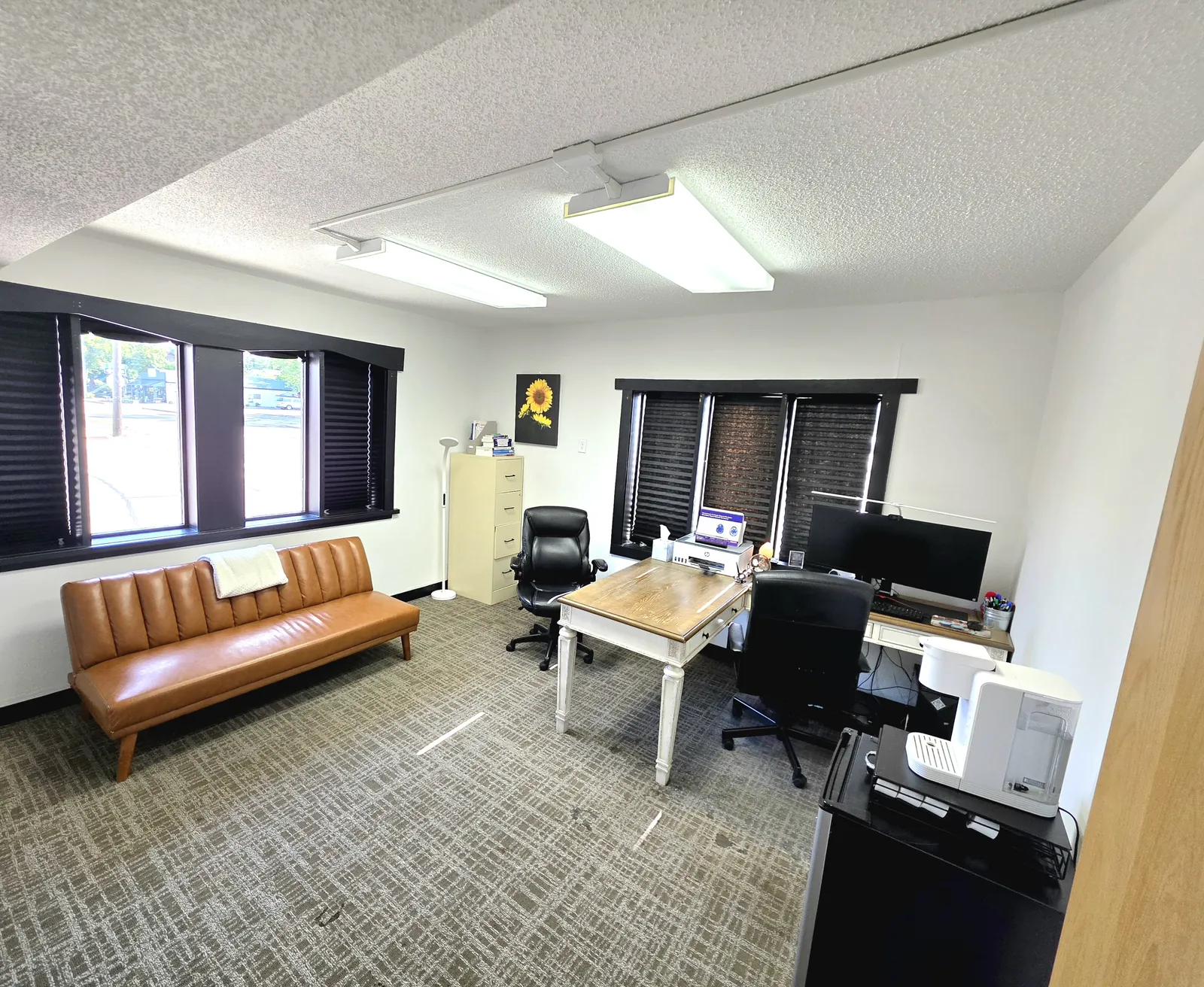 Private consultation room with natural light, seating, and a work desk